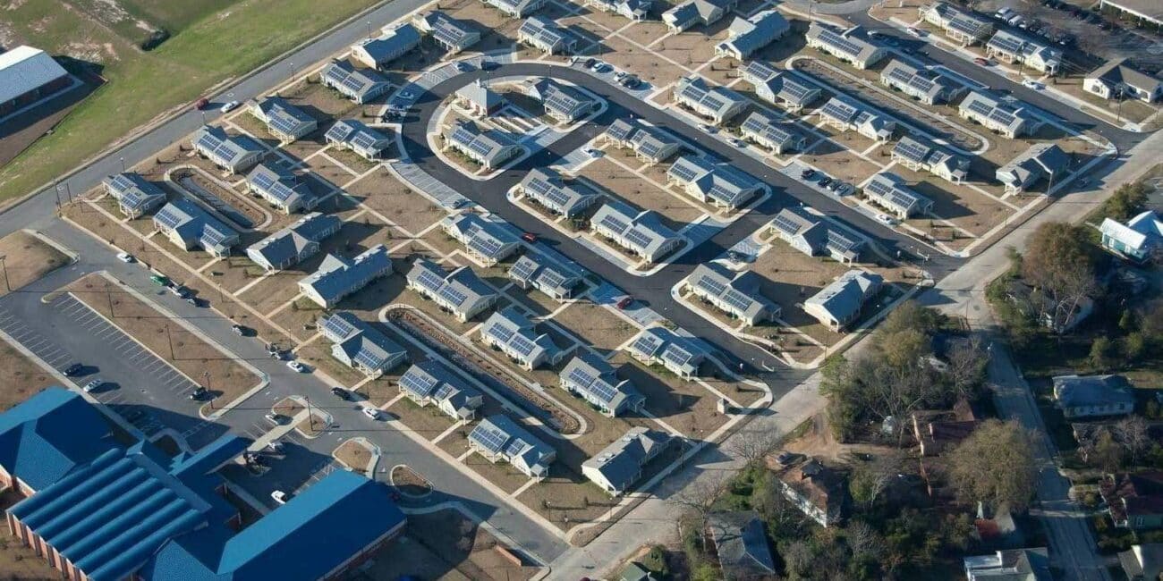 Aerial view of Felton Homes Apartments features grid-patterned single-story buildings, streets, parking lots, and greenery.